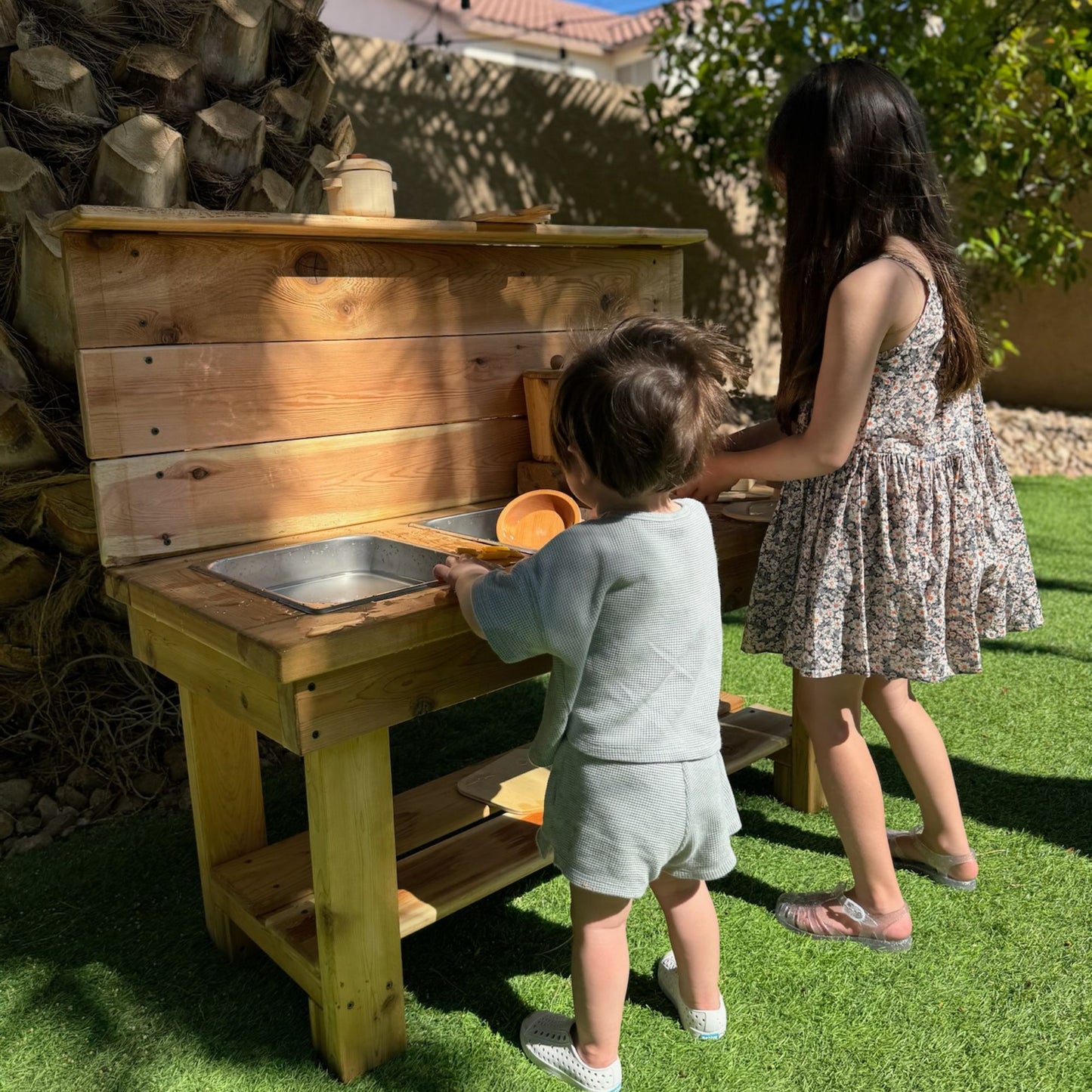 Kids enjoying outdoor mud kitchen play